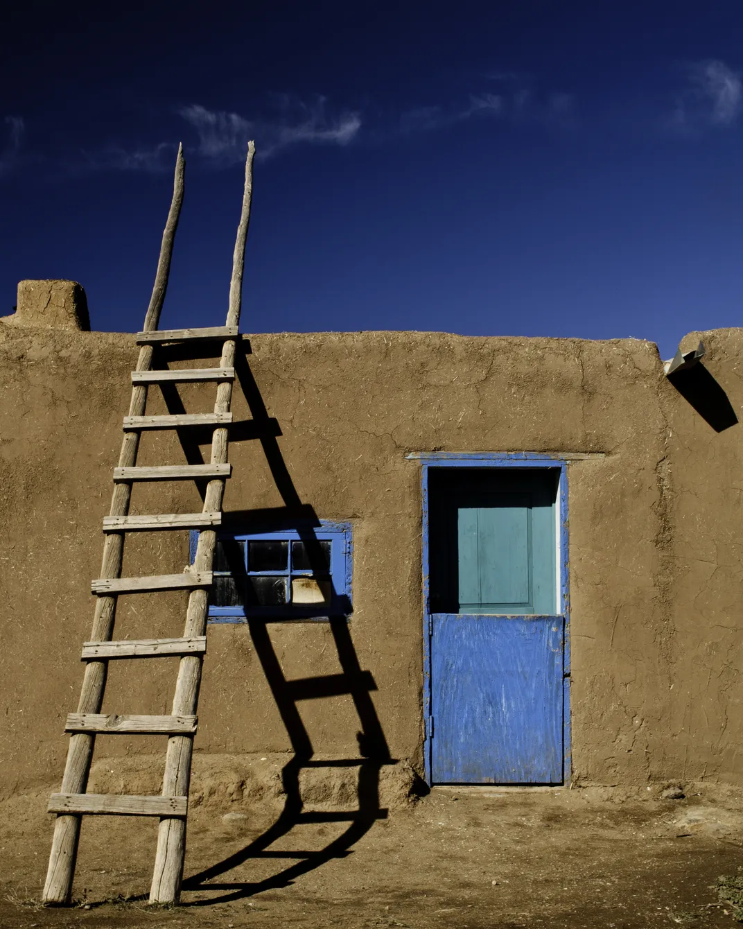 a ladder leans on a clay house