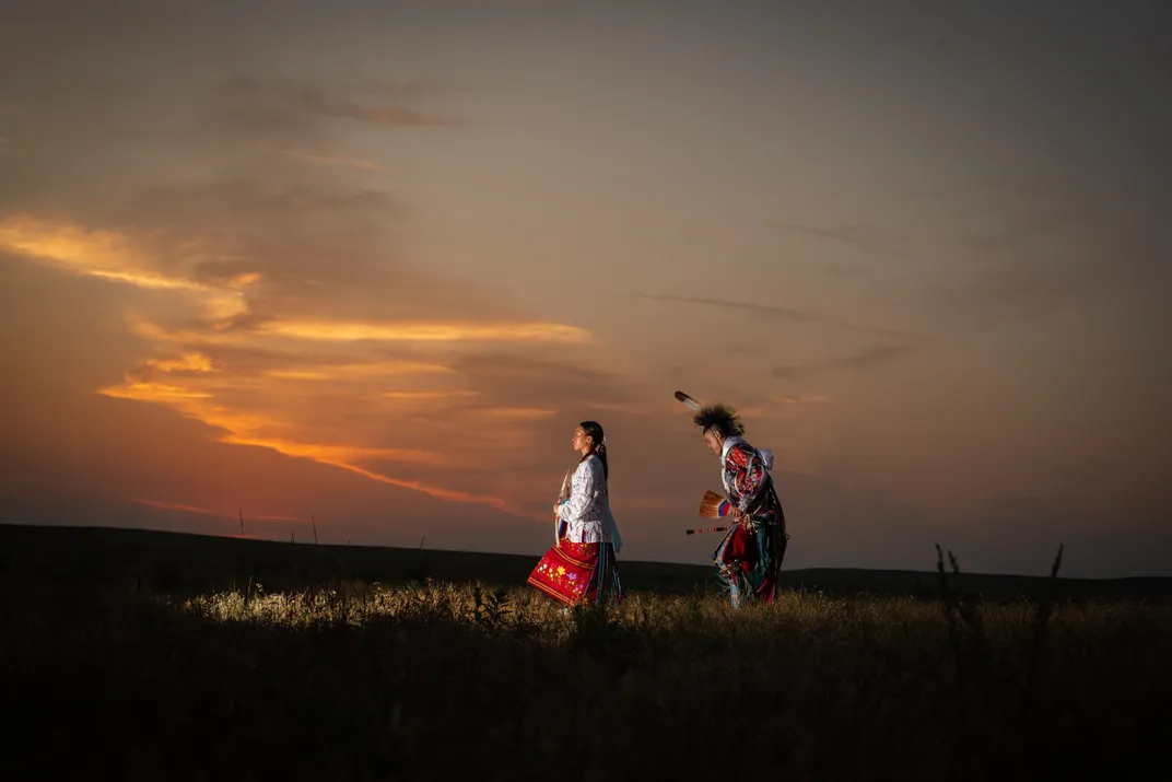 Osage Nation members dancing on a reservation during sunset