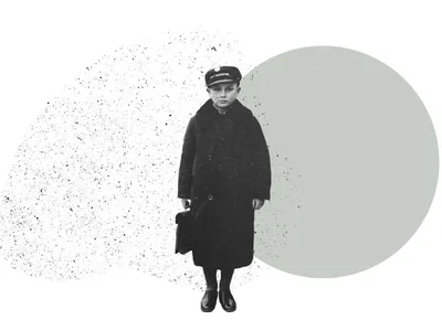 A boy in a long wool coat and hat holds a small case