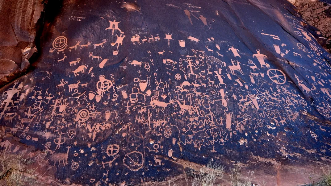 extremely dense Native American petroglyphs on a cliff wall