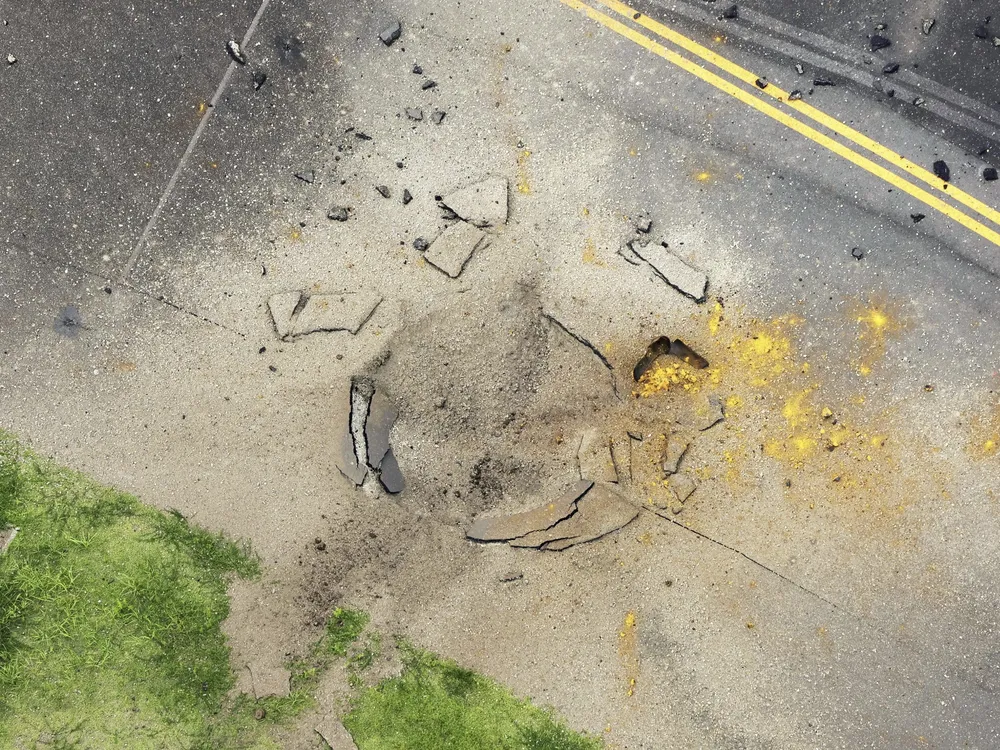 Overhead view of bomb crater in asphalt